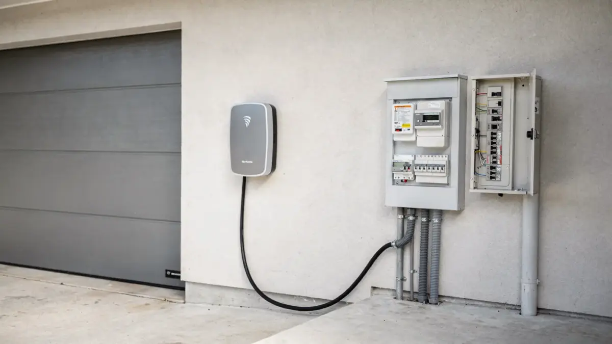 Wallbox an einer Hausgarage neben Stromzähler und Unterlagen zur Zuordnung des Netzbetreibers