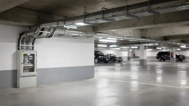 Kabelzuleitung in der Tiefgarage mit Kabelkanal, Verteilerkasten und Stellplatzmarkierung