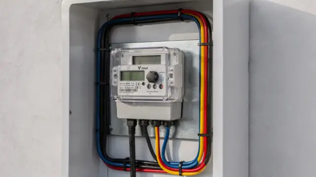 Wallbox mit integriertem Stromzähler und angeschlossenem Ladekabel in einer Garage für die Dienstwagen-Abrechnung.