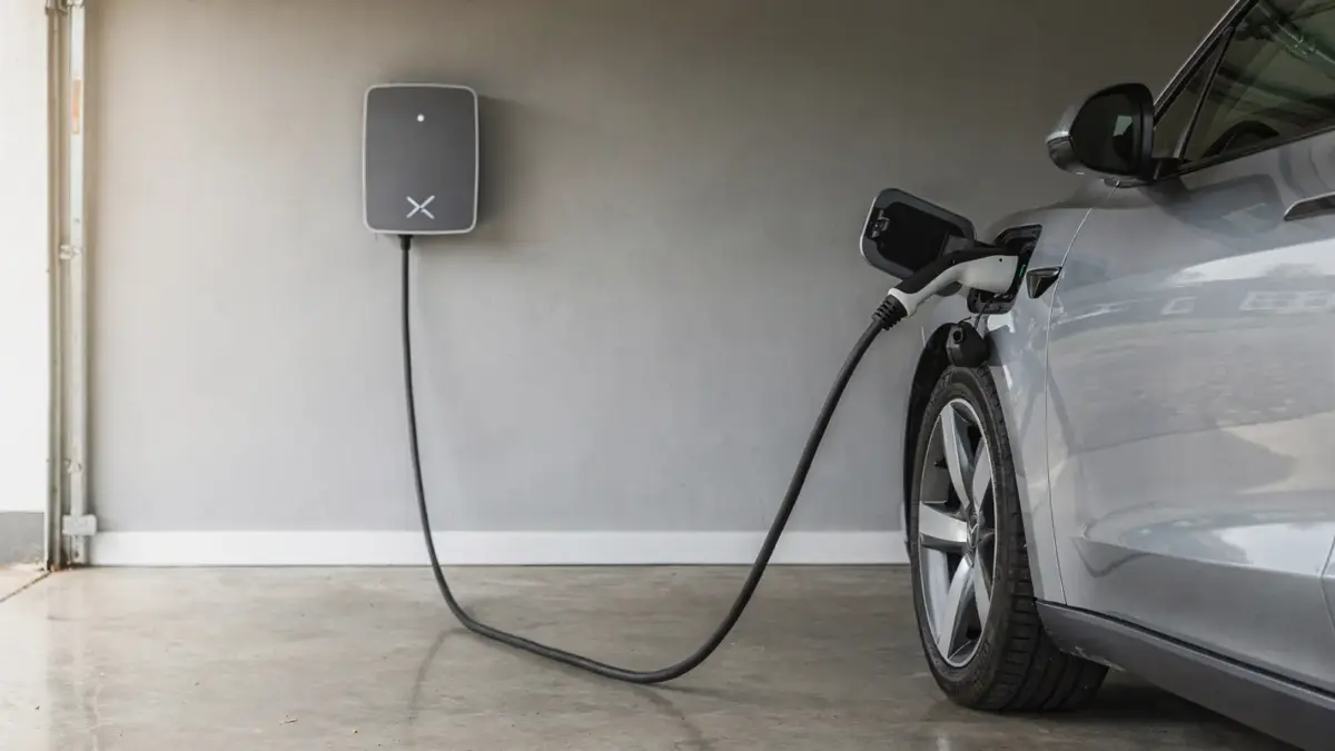 11-kW-Wallbox an der Garage mit angeschlossenem Elektroauto zum Thema Ladezeit