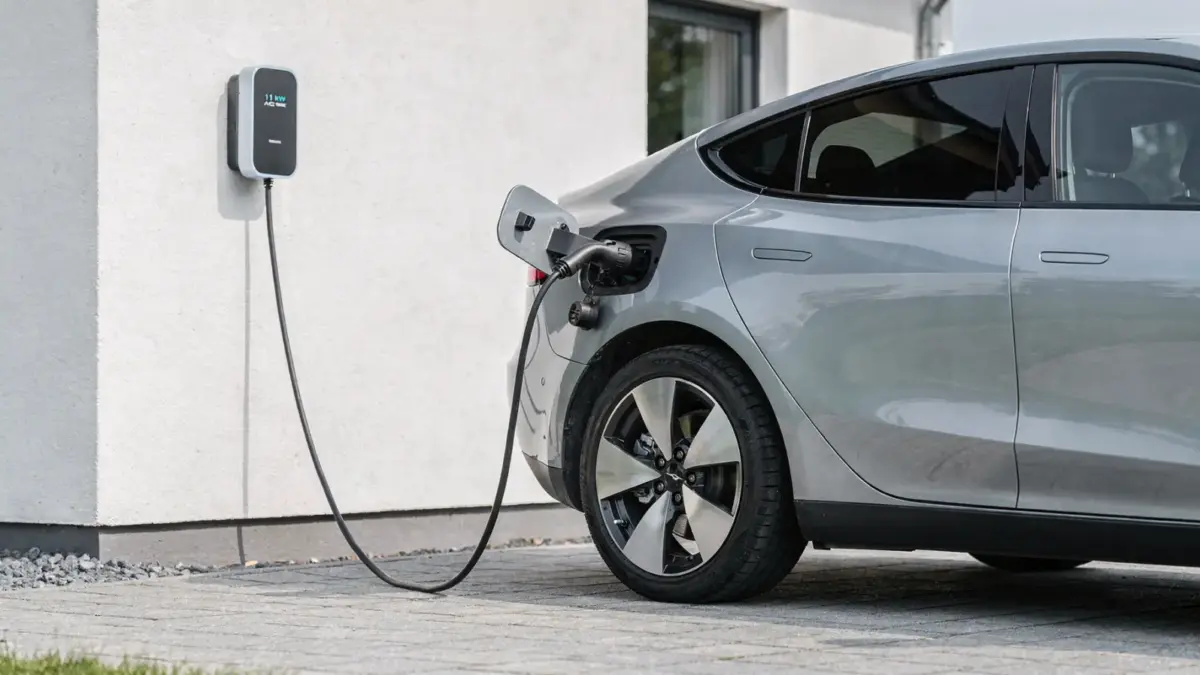 E-Auto an 11-kW-Ladestation beim Laden in der Einfahrt