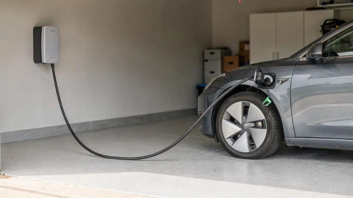 Wallbox an der Garage mit angeschlossenem Elektroauto zur Kompatibilität von Wallbox und E-Auto