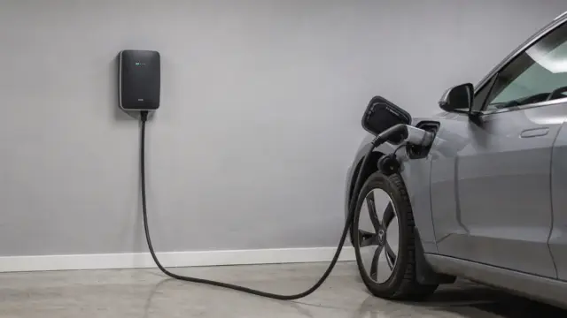 Elektroauto an Wallbox mit Ladekabel in einer Garage, Thema Phasenzahl beim Onboard-Lader