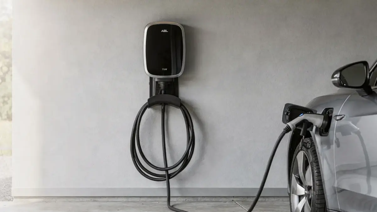 ABL Wallbox 11 kW an einer Garagenwand neben einem angeschlossenen Elektroauto